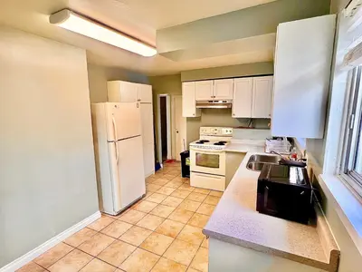 a kitchen with a white refrigerator and white cabinets at D3 Room Near Airport in Brampton
