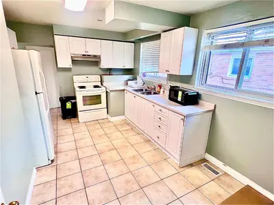 a kitchen with white appliances and a tile floor at Private Room Near Airport D4 in Brampton