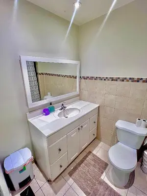 a bathroom with a sink and a toilet and a mirror at Private Room Near Airport D4 in Brampton