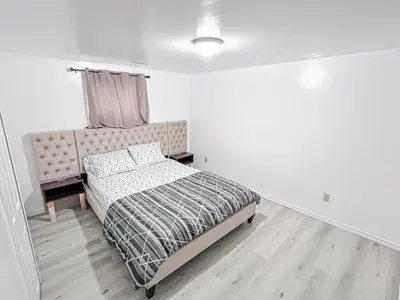 a white bedroom with a bed and a window at Private Room Near Airport D8 in Brampton