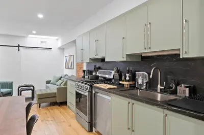 a kitchen with white cabinets and a stove top oven at Chic 2BR Top Floor Retreat with Rooftop Near Subway in Toronto