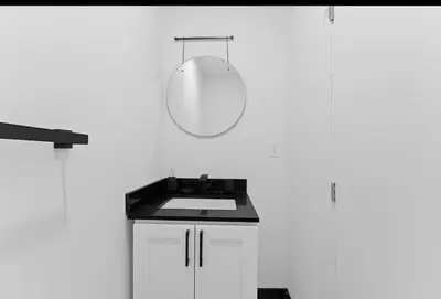 a bathroom with a sink and a mirror on the wall at Chic 2BR Top Floor Retreat with Rooftop Near Subway in Toronto