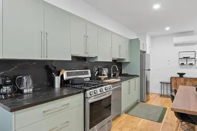 a kitchen with white cabinets and a stove top oven at Chic 2BR Top Floor Retreat with Rooftop Near Subway in Toronto