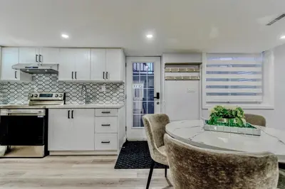 a kitchen with white cabinets and a table and chairs at Luxurious Unit in Hyde Park in London