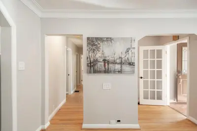a hallway with white walls and a painting on the wall at Charming 4BR Barrie Retreat with Backyard in Barrie