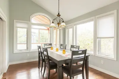 a dining room with a table and chairs and windows at Barrie Bliss 3BR Haven near Centennial Beach in Barrie