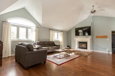 a living room with a couch and a fireplace at Barrie Bliss 3BR Haven near Centennial Beach in Barrie