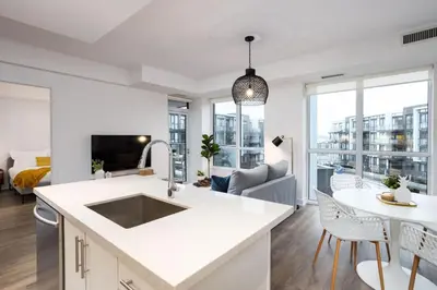 a kitchen with a sink and a living room at Amazing 2BR 2BA Resort Condo w Balcony and Parking in Barrie