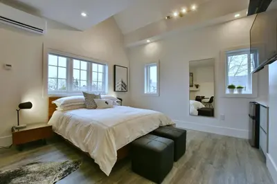 a bedroom with a large bed and a mirror at The VanderMarck Boutique Hotel in Collingwood