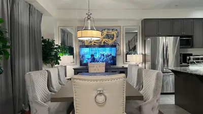 a dining room with a table and chairs and a television at 9 Queen Beds, 18 Guests-Kleinburg Luxe Crown Town Residence in Vaughan