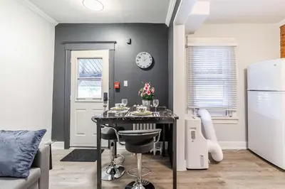 a kitchen with a table and a clock on a wall at Boutique 2BR Apartment on James St North Sleeps 6 in Hamilton