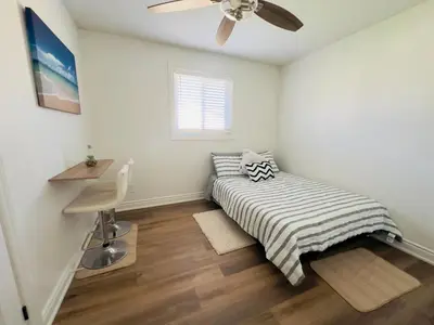 a white bedroom with a bed and a desk at Lovely Beachside Oasis 2BD in Port Dover in Port Dover