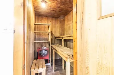 a wooden cabin with a bench and a table in it at Birch View- Balcony-Backyard-Parking-Sauna-Sleeps 20 in Blue Mountains