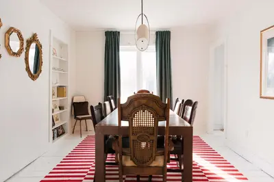 a dining room with a table and chairs on a red and white rug at Bloomfield Bliss - Hot Tub and Walking Distance to Park in Bloomfield