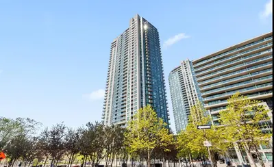 a tall building with trees in front of it at Luxury Downtown Condo with CN tower views, Pool Access, Gym,Free Parking upon request at booking, accommodates 4 in Toronto