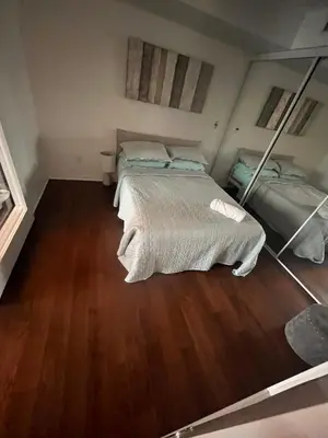 a bedroom with two beds and a wooden floor at Luxury Downtown Condo with CN tower views, Pool Access, Gym,Free Parking upon request at booking, accommodates 4 in Toronto