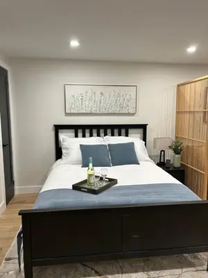 a bedroom with a large bed with a tray on it at Luxurious modern basement apartment in Pickering