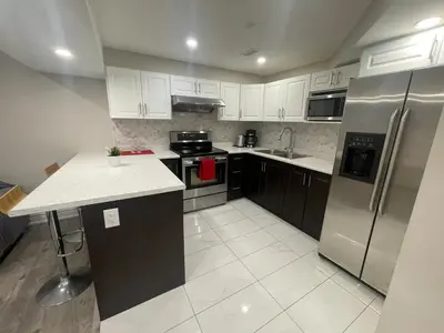 a kitchen with white cabinets and stainless steel appliances at CozyHaven A private entrance, comfy basement apartment in Mississauga with free parking Conveniently located with easy access to the airport downtown Toronto major malls and highways for a seamless stay in Mississauga