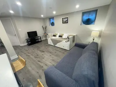 a living room with a couch and a bed at CozyHaven A private entrance, comfy basement apartment in Mississauga with free parking Conveniently located with easy access to the airport downtown Toronto major malls and highways for a seamless stay in Mississauga
