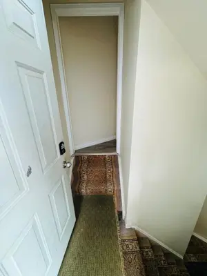 an empty hallway with a white door and a green rug at Sunnys Home Stays TorontoMississauga Pvt Entrance 2B'Rm Bath Living & Kitchen in Mississauga