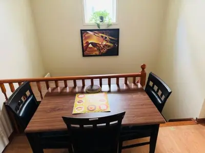 a dining room table with chairs and a wooden table at Sunnys Home Stays TorontoMississauga Pvt Entrance 2B'Rm Bath Living & Kitchen in Mississauga