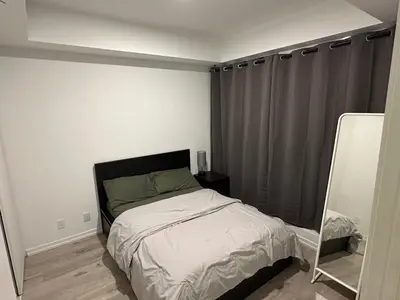a small bedroom with a bed and a mirror at The Evergreen Shelter in Vaughan