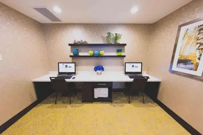 an office with three computers on a desk with three chairs at Hampton Inn & Suites by Hilton Bolton in Bolton