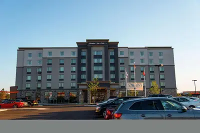 a large building with cars parked in a parking lot at Hampton Inn & Suites by Hilton Bolton in Bolton