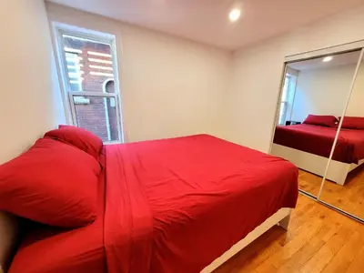 a bedroom with a red bed and a mirror at Deluxe Queen Rooms Downtown in Toronto