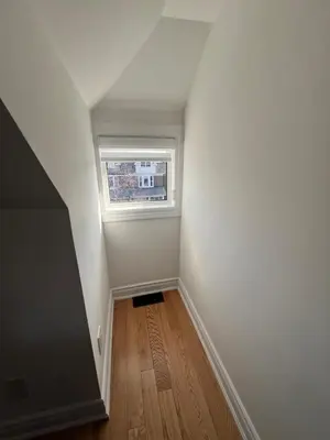 an empty room with a window and a wooden floor at Deluxe Queen Rooms Downtown in Toronto
