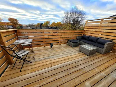 a wooden deck with a couch and a table at Deluxe Queen Rooms Downtown in Toronto