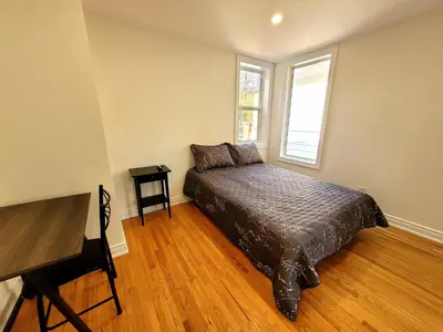 a bedroom with a bed and a window at Deluxe Queen Rooms Downtown in Toronto