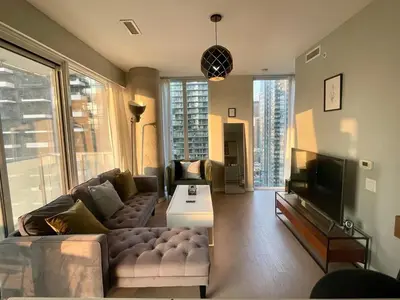 a living room with a couch and a tv at Stunning suite in downtown perfect for businesses trips and small families in Toronto