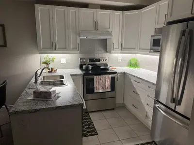 a kitchen with white cabinets and stainless steel appliances at A Compact family home in Milton in Milton