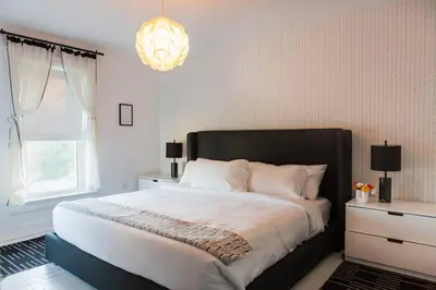 a bedroom with a large bed and a chandelier at The Vue - Nestled by Roblin's Lake with a Hot Tub in Mountain View