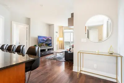 a living room with a mirror and a table at Executive 2BR 2BATH Condo with Lakeview Steps from SQ1 in Mississauga