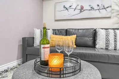 a bottle of wine and two wine glasses on a table at Family-Friendly 2BR Ground-Level Suite with Full Kitchen, Parking and 20 Minutes to Downtown in Toronto
