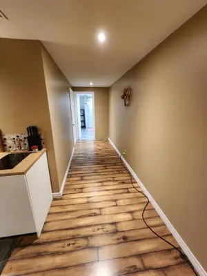 a hallway of a house with a wooden floor at The Cozy Den in Ingersoll