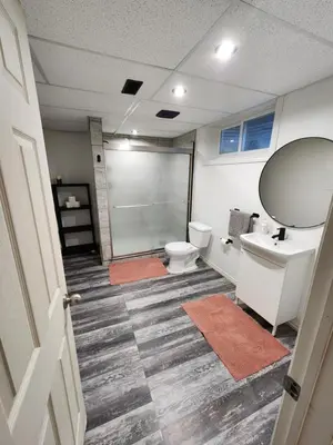 a bathroom with a shower and a toilet and a sink at The Cozy Den in Ingersoll