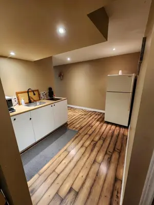 an empty kitchen with a sink and a refrigerator at The Cozy Den in Ingersoll