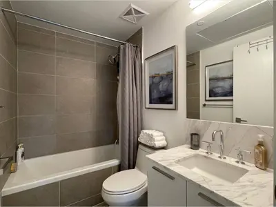 a bathroom with a sink and a toilet and a tub at Toronto Bloor & Yonge Luxury Condo in Toronto