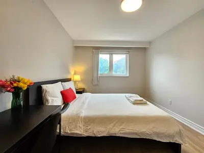 a bedroom with a large bed and a window at A Home Away-Cozy Guest Room in Toronto in Toronto