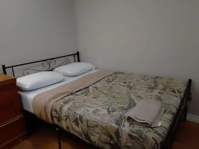 a bedroom with a bed with a blanket and pillows at Cheap Rooms in Kitchener Best For Students ,Long Term Guests in Kitchener