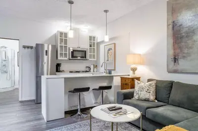 a living room with a couch and a kitchen at 1 bedroom Garden Suite with parking, Best Location in Collingwood