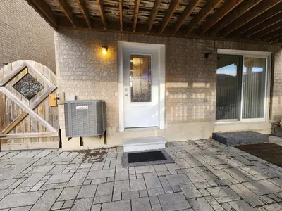 a house with a white door and a gate at Cozy Walkout Suite in Vaughan