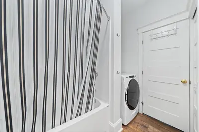 a white bathroom with a toilet and a mirror at The Chickadee - 21 Farm View in Cherry Valley