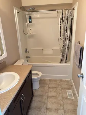 a bathroom with a tub and a toilet and a sink at 2 beds suit in Kitchener