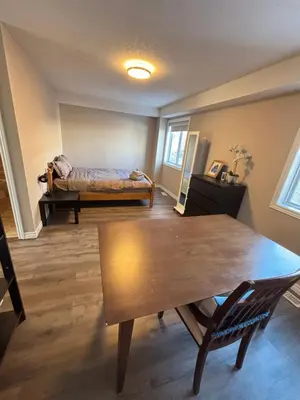 a bedroom with a table and a bed in a room at 2 beds suit in Kitchener