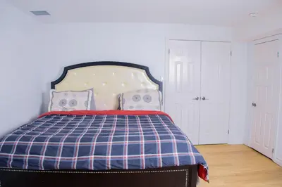 a bedroom with a bed with a blue and white plaid blanket at Cozy relaxation haven 1 Bedroom basement in London