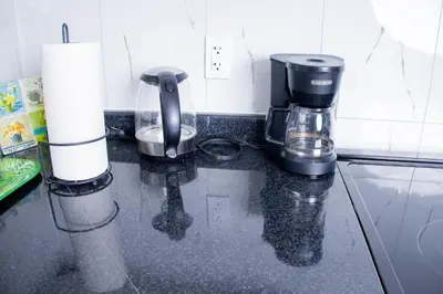 a black counter top with a coffee maker on it at Cozy relaxation haven 1 Bedroom basement in London